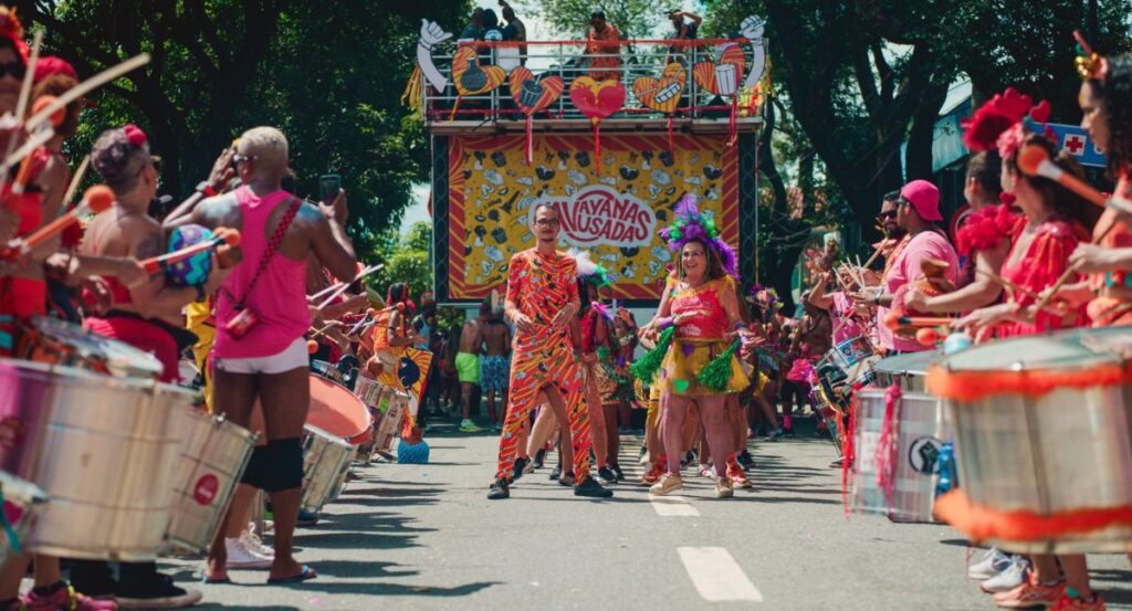 Na foto, momento de cortejo do Havayanas Usadas, um dos blocos que participam do pré-carnaval (MIlena do Carmo/Divulgação)